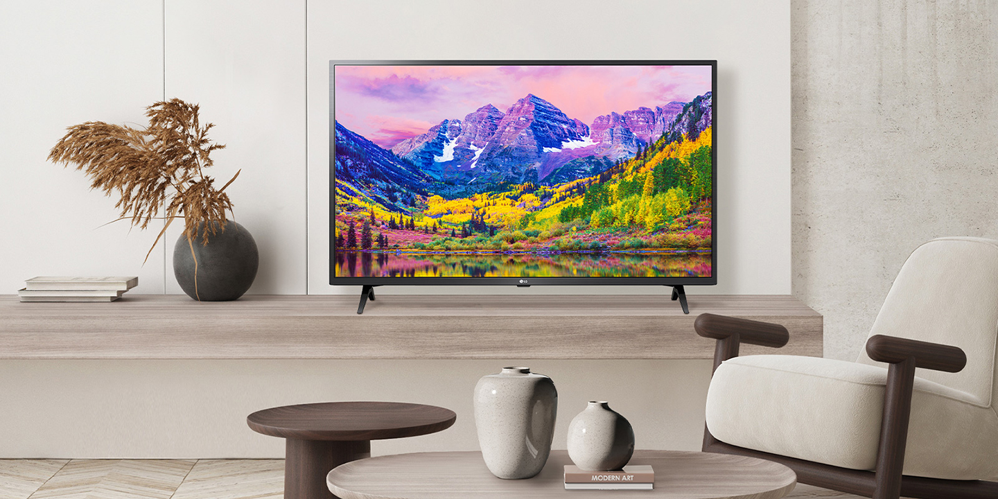 A TV is installed on a stand close to the wall in the hotel room, and the screen is bright and clear.